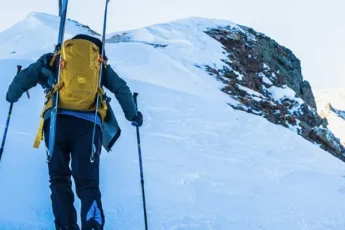 un skieur remontant la montagne à pied